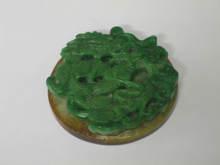 A circular carved jade coloured pendant