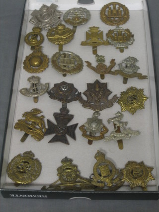 A Highland Light Infantry badge, a Hampshire Regt., Northamptonshire and 20 other various cap badges