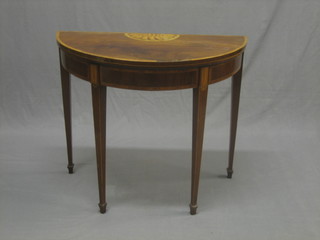 A handsome Georgian mahogany demi-lune card table with crossbanded top and inlaid a shell, raised on square tapering supports (some crossbanding missing and some old worm) 33"