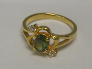 A gold dress ring set a peridot and 2 white stones