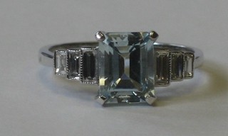 An 18ct white gold dress ring set a rectangular cut aquamarine and 6 baguette cut diamonds to the shoulders