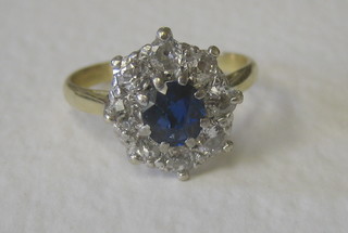 A lady's attractive gold dress ring set an oval cut sapphire supported by diamonds