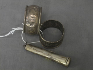 A silver cased cigar holder and a pair of silver napkin rings