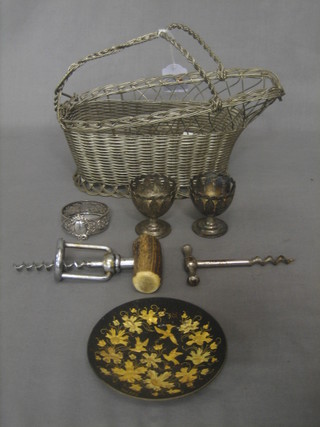 A silver plated wire work wine bottle cradle, a napkin ring, 2 cork screws and an Eastern gilt metal dish