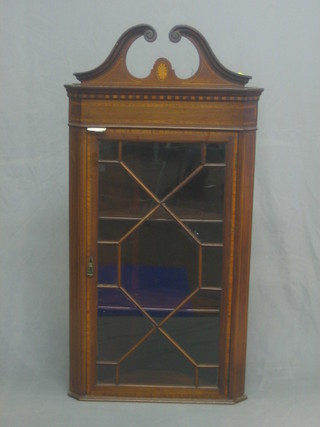 A 19th Century inlaid mahogany hanging corner cabinet with broken pediment, the interior fitted shelves enclosed by an astragal glazed panelled door 23"