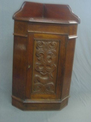 A Victorian carved walnut and oak corner cabinet with raised back, the base fitted shelves enclosed by a panelled door 29"