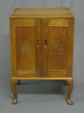 A bleached carved Kashmiri hardwood cabinet enclosed by panelled doors, raised on cabriole supports 20"