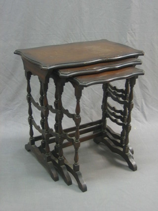 A nest of 3 interfitting mahogany coffee tables with shaded tops and ladder back decoration 24" 