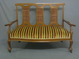 An Edwardian Art Nouveau walnut bar back sofa raised on cabriole supports 52"