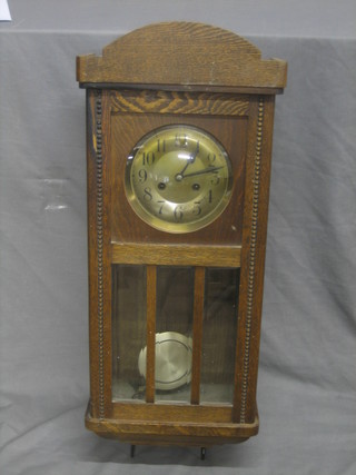 A 1930's striking wall clock with silvered dial and Arabic numerals contained in an oak case