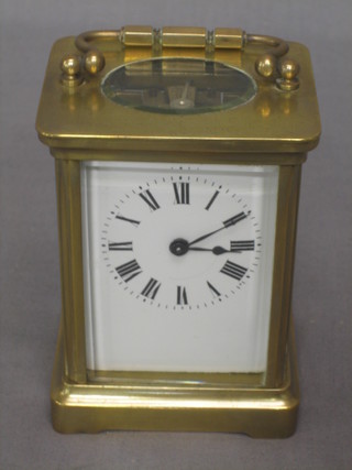 A 19th Century French carriage clock with enamelled dial and Roman numerals contained in a gilt case