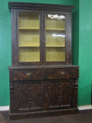 A 19th Century pine scumbled painted bookcase on cabinet, the upper section with moulded cornice the interior fitted shelves, the base fitted 2 drawers above a double cupboard with column decoration to the side 52"