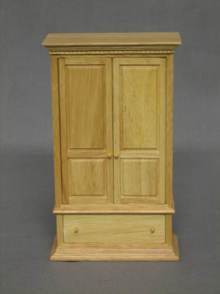 A dolls house pine wardrobe enclosed by double panelled doors, the base fitted a drawer 3"