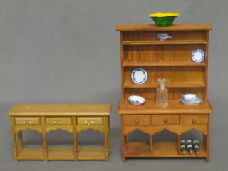 A dolls house pine dresser with raised back and an oak finished dresser base