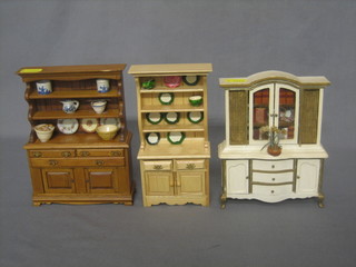 A dolls house oak dresser with raised back 5", a pine dresser with raised back 4" and a Continental style dresser with raised back 5"