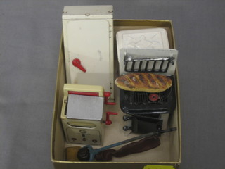 A dolls house cast metal refrigerator, a cast metal stove, a metal vacuum cleaner, a pressed metal dolls house cabinet and a washing machine
