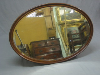 An Edwardian oval bevelled plate wall mirror contained in an inlaid mahogany frame 39"