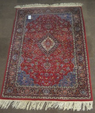 A fine quality red ground and floral patterned Persian rug with central medallion 84" x 56"