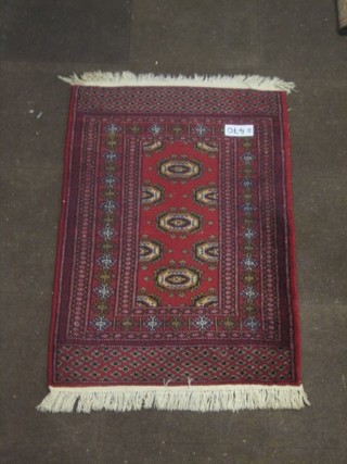 A red ground Afghan rug with octagons to the centre within a multi-row border 47" x 30"