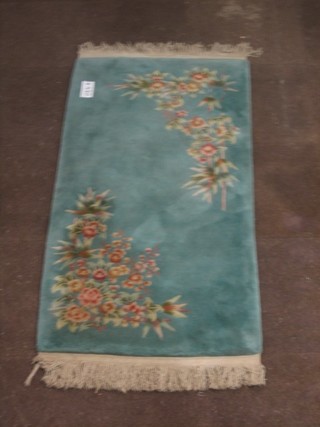 A green ground and floral patterned Chinese rug 61" x 30"