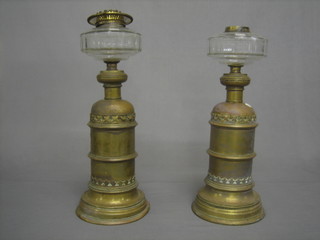A pair of brass oil lamp bases with clear glass chimneys 18"