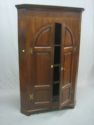 A Georgian mahogany corner cabinet with moulded cornice, the interior fitted shelves and 3 spice drawers enclosed by a arch shaped panelled doors with ivory escutcheons 35"