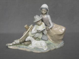 A Lladro figure of a seated boy and girl with book and lamb 8" (f and r)
