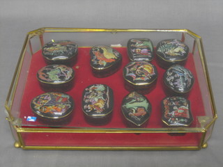 11 various Franklyn porcelain musical trinket boxes contained in a gilt metal case