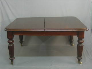 A Victorian mahogany extending dining table with 2 extra leaves, raised on turned and reeded supports