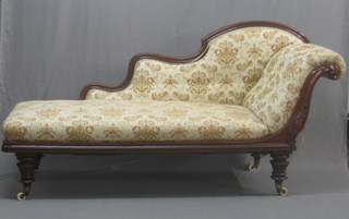 A Victorian carved mahogany showframe chaise longue raised on turned supports 72"