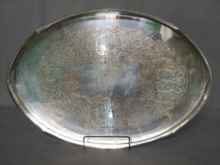 An oval silver plated tea tray with pierced and engraved decoration 24"