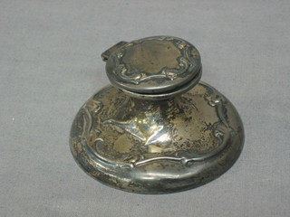 A circular silver capstan inkwell with hinged lid and embossed decoration, complete with glass liner (slight tear to base) 3"