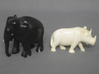 A carved ivory figure of a Rhino 3" and an ebony figure of an elephant 3"