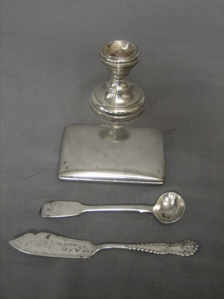 A continental silver cigarette case, a small stub candlestick, a silver butter knife and a silver mustard spoon