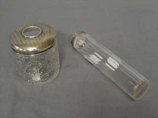 A cylindrical glass pin jar with silver lid and a cylindrical hair tidy