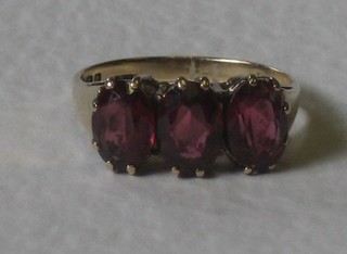A 9ct gold dress ring set 3 oval red cut stones