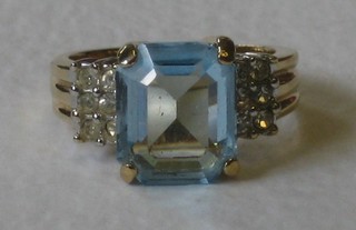 A lady's 18ct yellow gold dress ring set a rectangular cut aquamarine supported by 6 diamonds to the shoulders