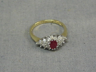 A 9ct gold dress ring set an oval ruby surrounded by diamonds