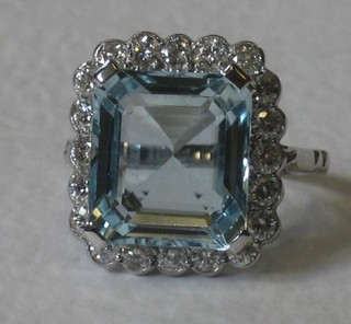 A lady's 18ct white gold dress ring set a large rectangular cut aquamarine supported by numerous diamonds, approx 1/8.10ct