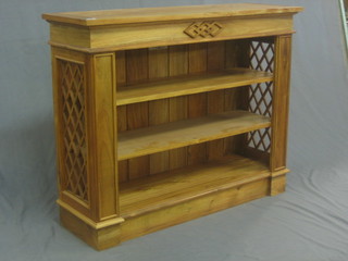 A Georgian style bleached mahogany bookcase with adjustable shelves and fret work decoration to the sides, raised on a platform base 42"