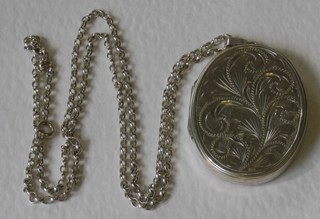 A fine silver chain hung an engraved locket