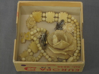 An ivory brooch in the form of a flower head, a carved ivory bracelet and a pair of ivory ear clips in the form of roses