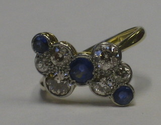 An 18ct gold dress ring set 3 sapphires supported by 6 diamonds