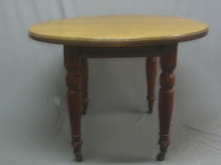 A Victorian honey oak extending dining table raised on turned supports with 1 extra leaf 44"