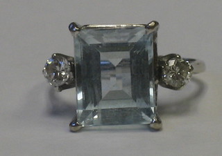 A lady's white gold dress ring set an aquamarine supported by diamonds