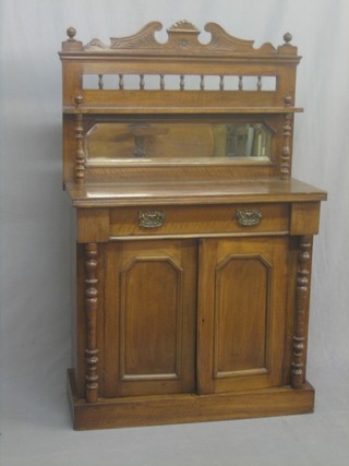 A Victorian mahogany chiffonier with raised mirrored back, the base fitted a drawer above a double cupboard with column decoration to the sides, raised on a platform base 34"
