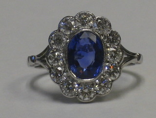 A lady's 18ct white gold dress ring set an oval sapphire supported by numerous diamonds approx. 1/1.55ct