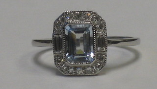 A lady's 18ct white gold dress ring set a rectangular cut aquamarine supported by numerous diamonds