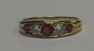 A lady's 18ct yellow gold dress ring set 3 rubies supported by 2 diamonds