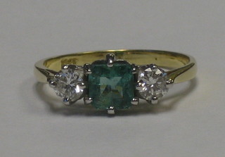 A lady's 18ct yellow gold dress ring set a square cut emerald supported by 2 diamonds approx 0.50ct